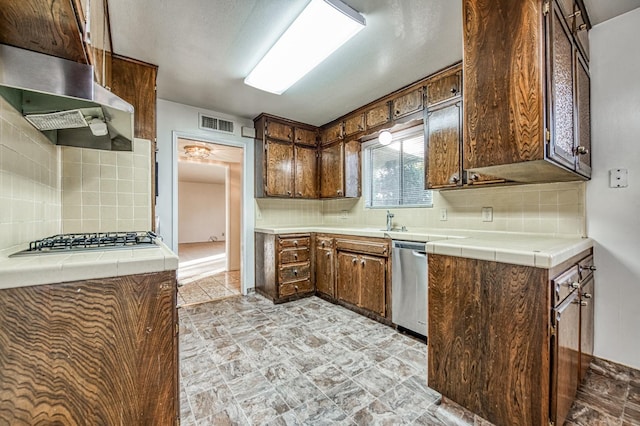 kitchen featuring tile counters, stainless steel appliances, and backsplash