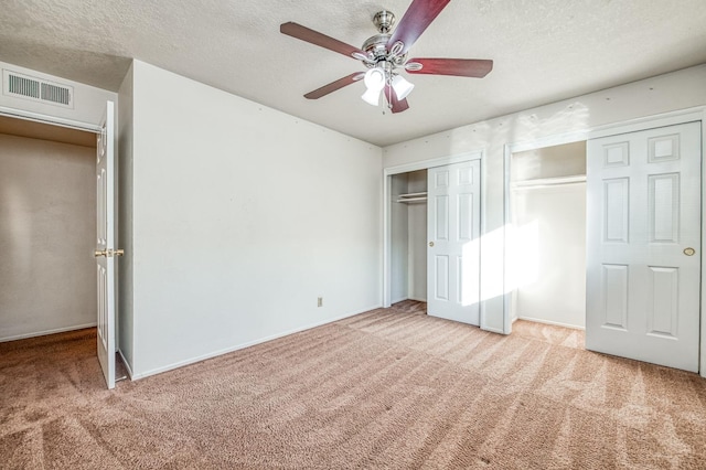 unfurnished bedroom featuring a textured ceiling, light colored carpet, and ceiling fan