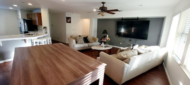 living room with ceiling fan, sink, and dark hardwood / wood-style floors