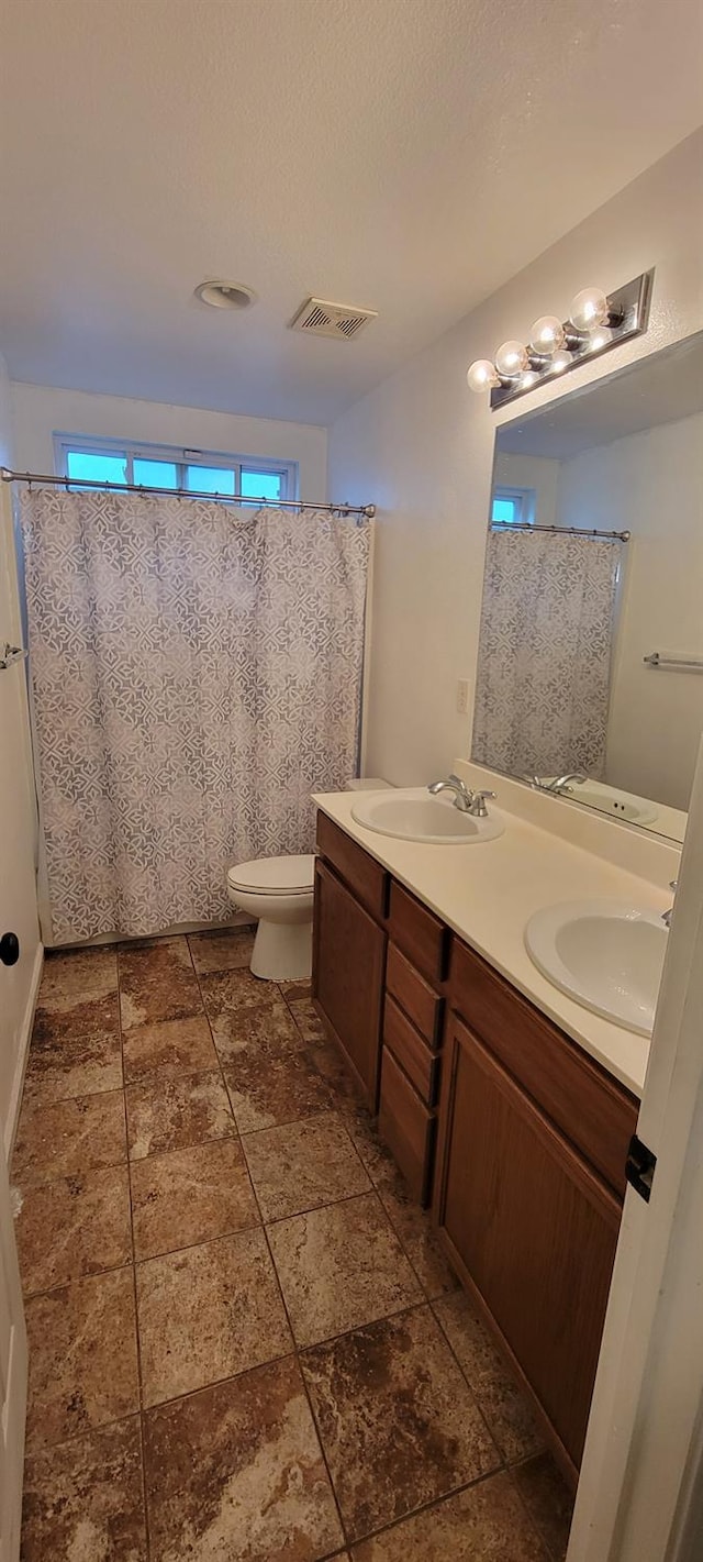 bathroom featuring toilet, vanity, and a textured ceiling