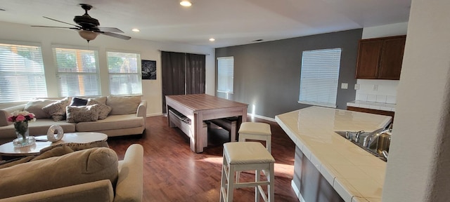 living room featuring ceiling fan, dark hardwood / wood-style floors, plenty of natural light, and sink