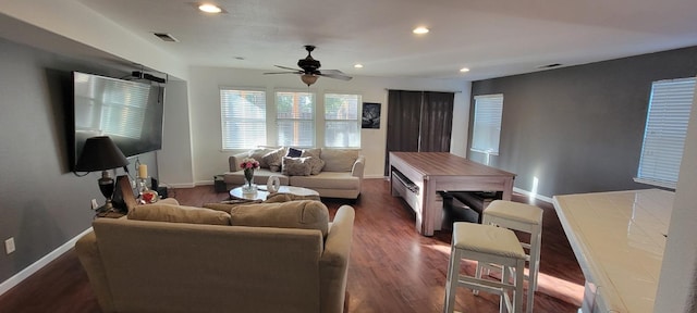 living room featuring dark wood-type flooring and ceiling fan