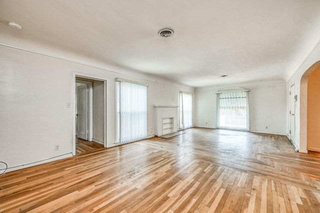 unfurnished living room featuring a brick fireplace and light wood-type flooring