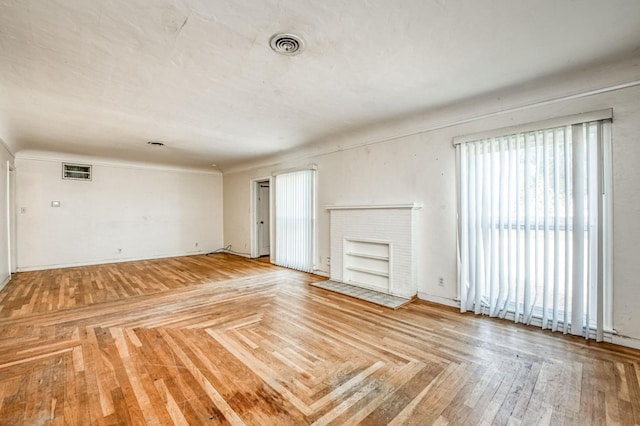 unfurnished living room with a brick fireplace and a wealth of natural light