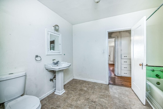 bathroom featuring sink, a bathtub, and toilet