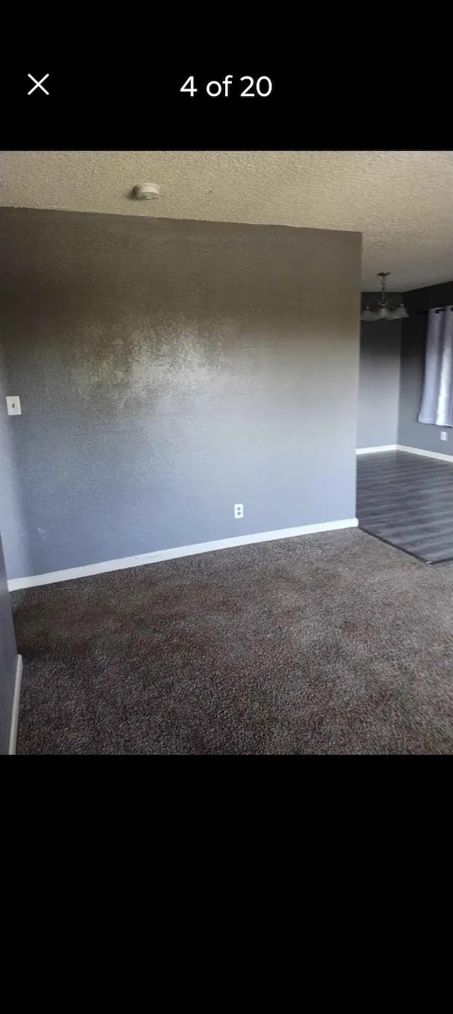 carpeted empty room featuring a textured ceiling