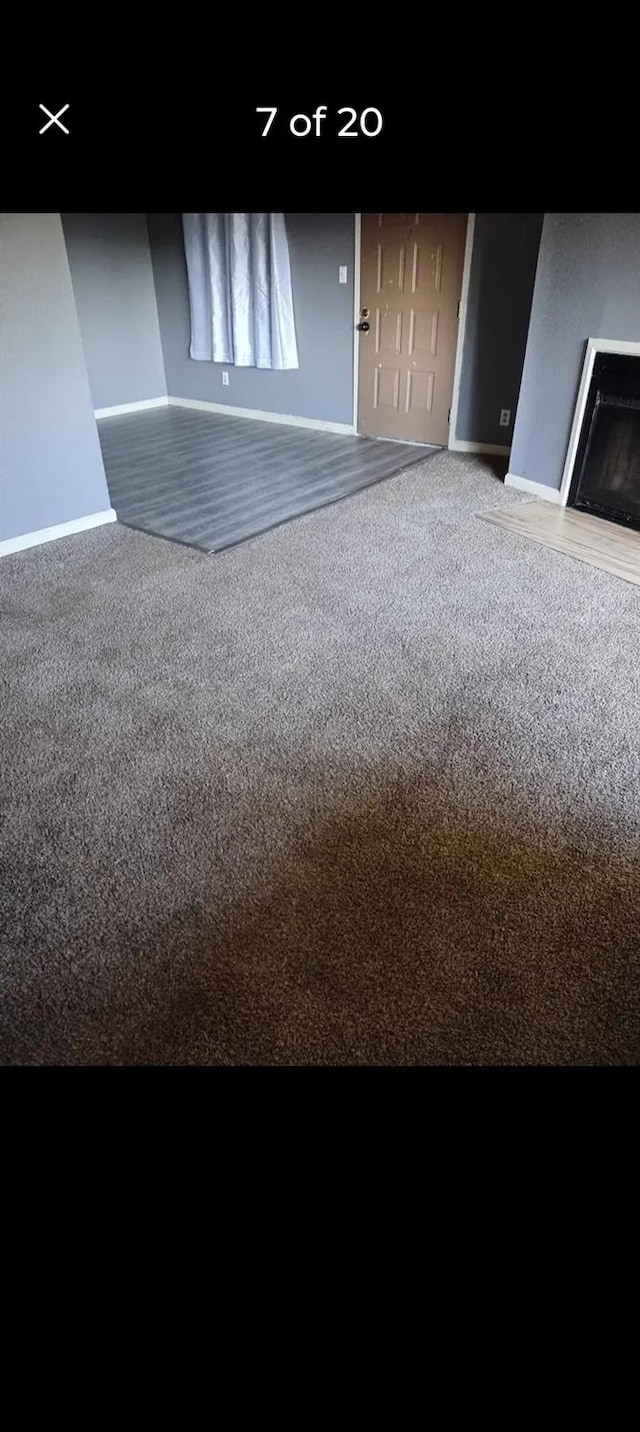 carpeted spare room featuring a fireplace