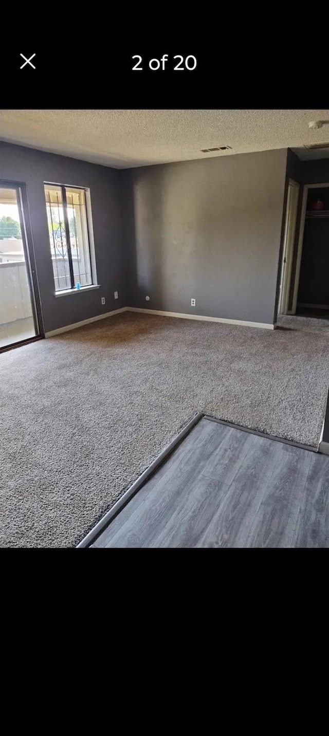 empty room featuring a textured ceiling and carpet flooring