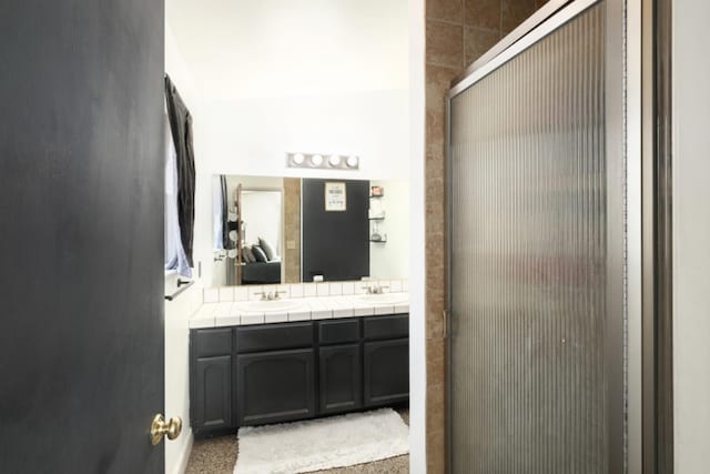 bathroom with vanity and a shower with door