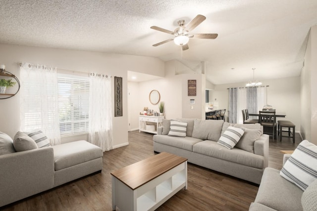 living room featuring a textured ceiling, ceiling fan with notable chandelier, dark wood-type flooring, and lofted ceiling