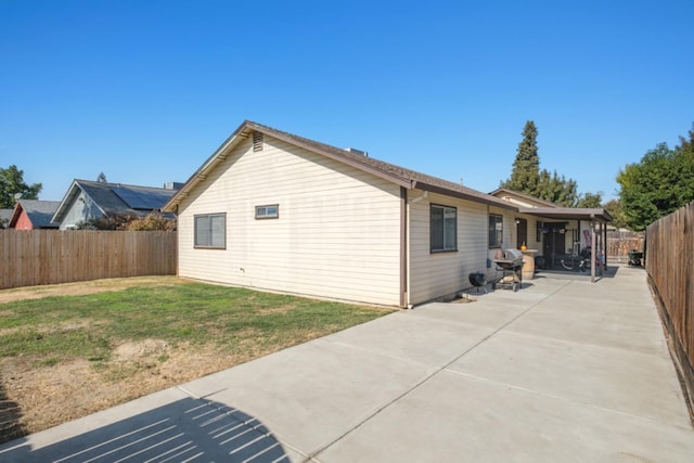 back of house featuring a yard and a patio