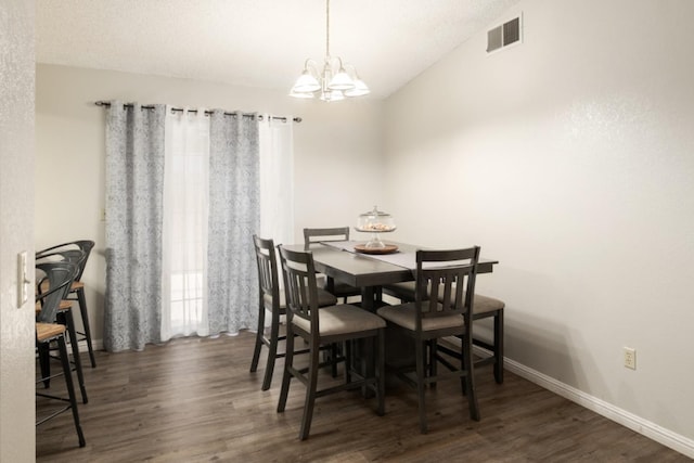 dining space with vaulted ceiling, dark wood-type flooring, and a notable chandelier