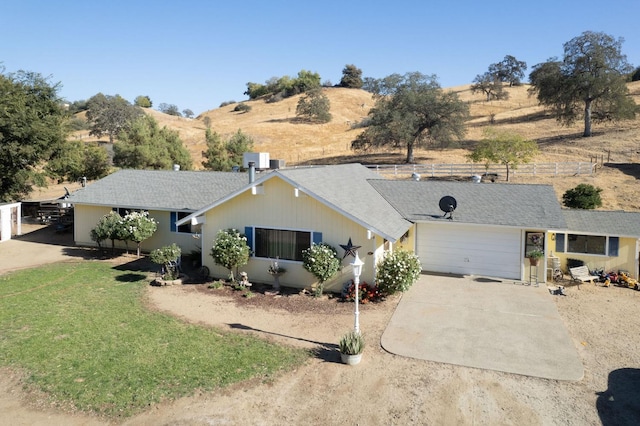 single story home with a garage, a mountain view, and a front lawn