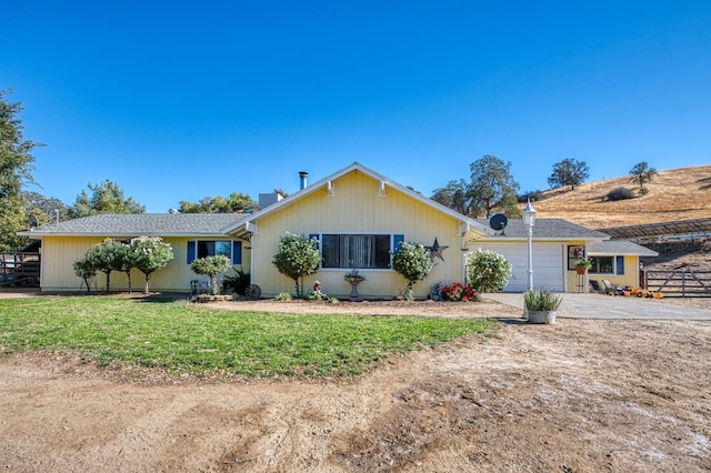 single story home with a garage and a front lawn