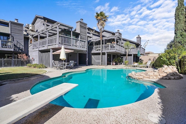 view of swimming pool featuring a diving board and a wooden deck