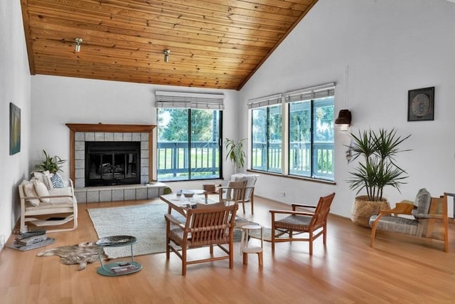 living room featuring a fireplace, wood-type flooring, wood ceiling, and high vaulted ceiling