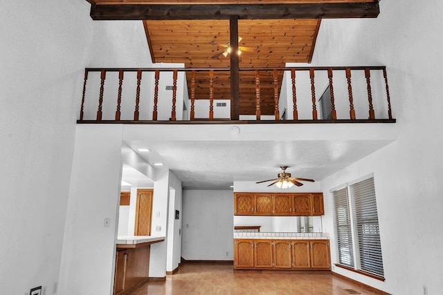 kitchen featuring light hardwood / wood-style flooring, a textured ceiling, ceiling fan, and beam ceiling