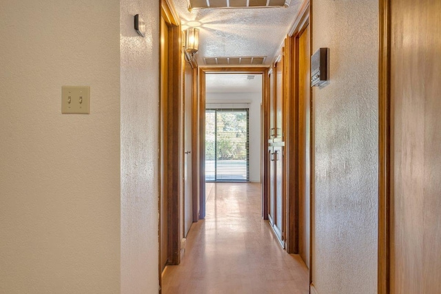 corridor featuring a textured ceiling