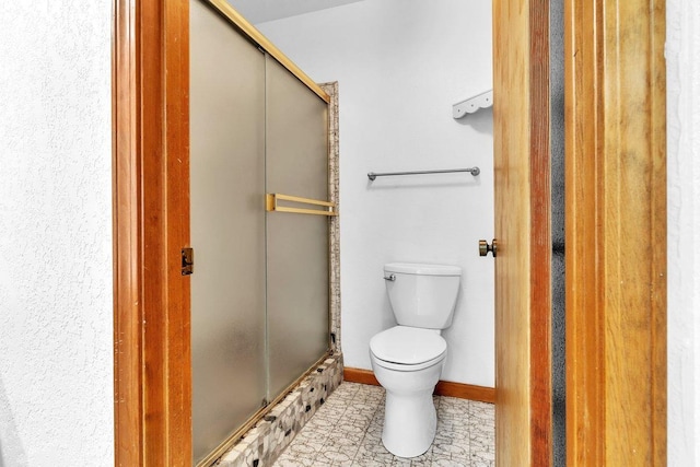 bathroom with an enclosed shower, tile patterned floors, and toilet