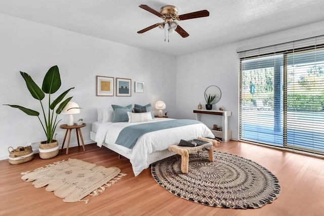 bedroom with hardwood / wood-style floors, ceiling fan, a textured ceiling, and access to outside