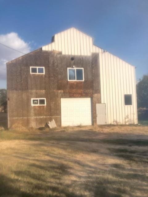 view of side of property with a garage and a lawn