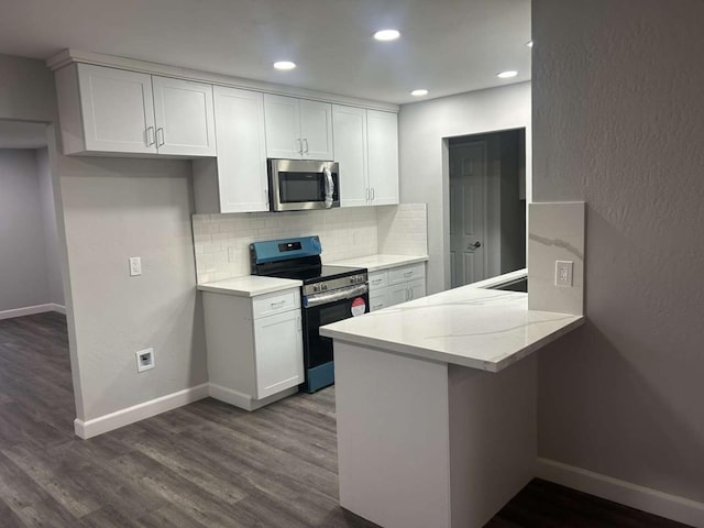 kitchen featuring appliances with stainless steel finishes, backsplash, light stone countertops, white cabinets, and dark hardwood / wood-style flooring