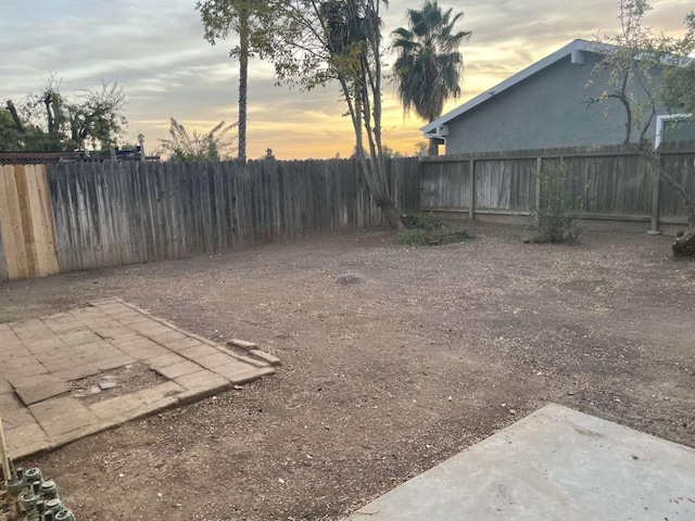 yard at dusk featuring a patio