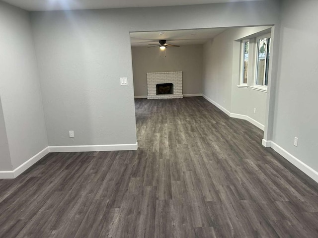 unfurnished living room featuring dark wood-type flooring, a fireplace, and ceiling fan