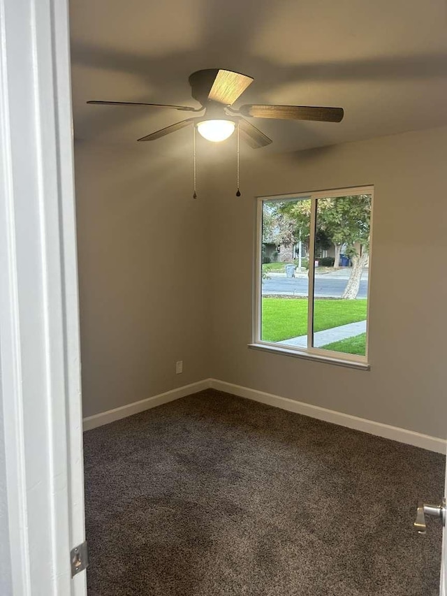 carpeted spare room featuring ceiling fan