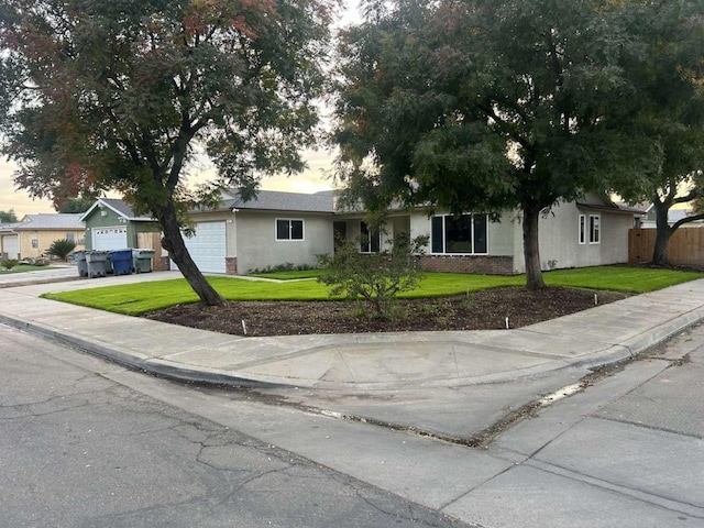 ranch-style house with a garage and a lawn