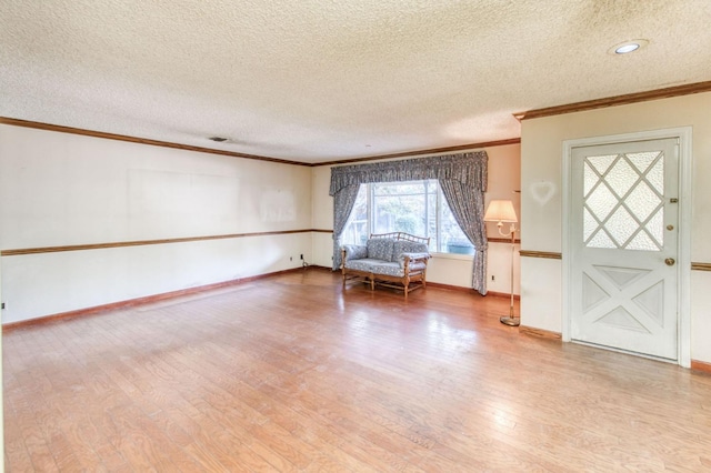 unfurnished room with hardwood / wood-style floors, crown molding, and a textured ceiling