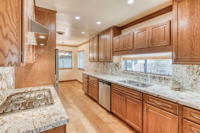 kitchen featuring ornamental molding, stainless steel appliances, decorative light fixtures, sink, and light hardwood / wood-style flooring