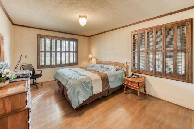 bedroom with light wood-type flooring, a textured ceiling, and ornamental molding