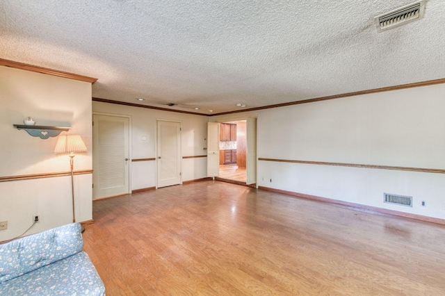 unfurnished living room featuring ornamental molding, light hardwood / wood-style flooring, and a textured ceiling