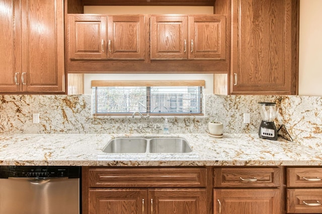 kitchen featuring light stone counters, sink, backsplash, and dishwasher