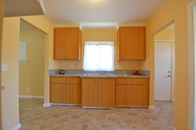 339 N Delno Ave, Fresno, CA 93706 - kitchen with a sink, light stone countertops, baseboards, and brown cabinets