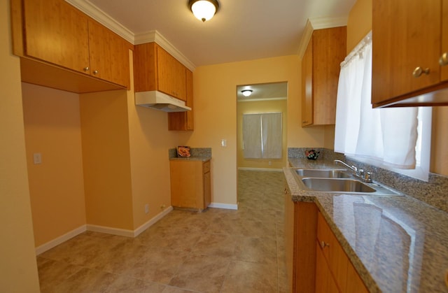 339 N Delno Ave, Fresno, CA 93706 - kitchen with a sink, under cabinet range hood, brown cabinets, light stone counters, and baseboards