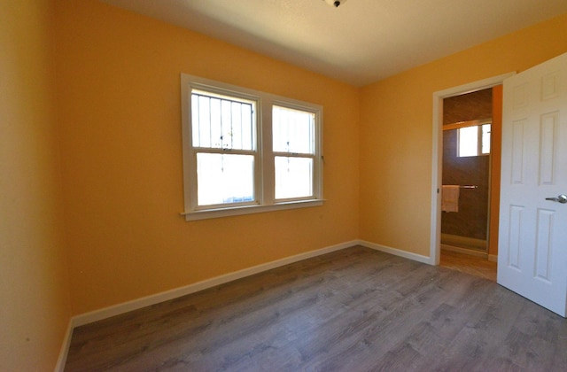 unfurnished bedroom featuring hardwood / wood-style flooring and multiple windows