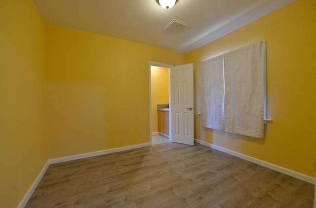 unfurnished room with hardwood / wood-style flooring