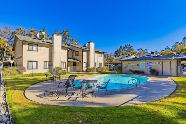 view of pool with a lawn and a patio