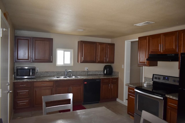 kitchen with sink, light tile patterned flooring, stainless steel appliances, and stone countertops