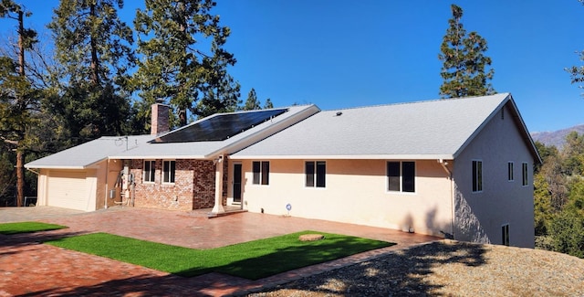 view of front facade featuring a patio area and solar panels