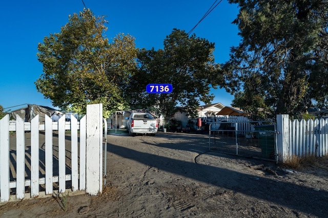 view of street featuring driveway, a gated entry, and a gate