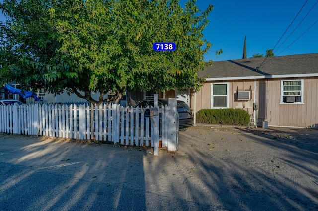 view of front of property featuring roof with shingles and a fenced front yard
