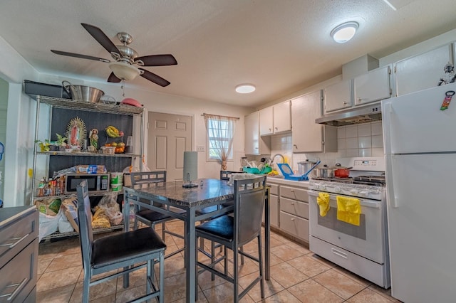 kitchen with tasteful backsplash, white appliances, white cabinetry, under cabinet range hood, and ceiling fan