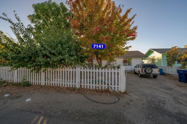 view of property hidden behind natural elements with a fenced front yard
