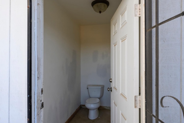 bathroom with toilet and baseboards