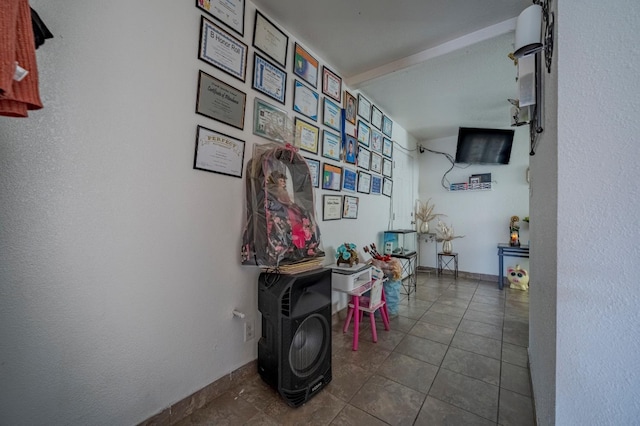 hall featuring tile patterned floors and baseboards