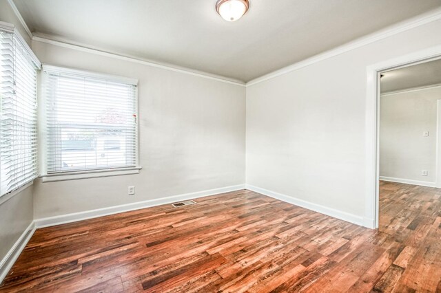 empty room featuring ornamental molding and wood-type flooring