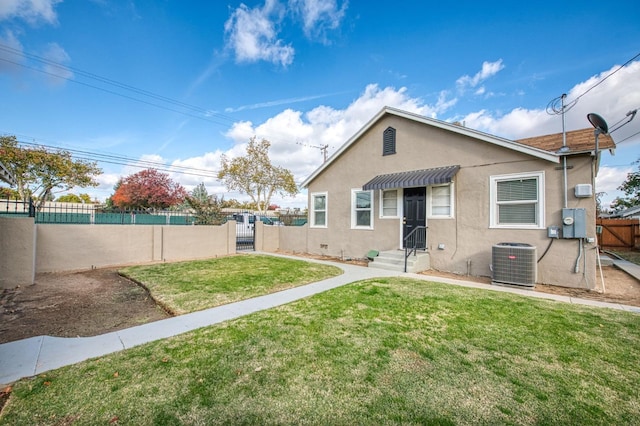 bungalow-style home featuring central AC and a front yard